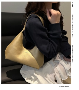 Close-up of metallic golden hobo bag with Fashion & Bags logo on model shoulder