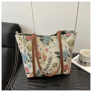 Close-up of floral jacquard fabric and brown leather handle on a chic tote bag