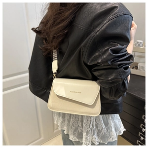 Detail of minimalist cream leather handbag with black and white checkerboard wide strap