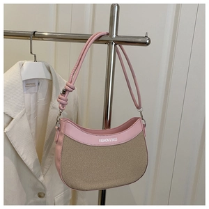 Détail du sac hobo en cuir rose et texture tissée avec nœud décoratif sur la bandoulière
