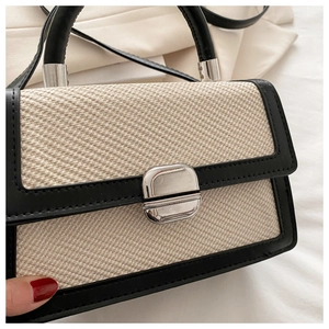 Détails du sac bandoulière bicolore en paille avec boucle métallique argentée