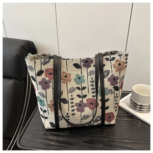 Close-up of floral jacquard tote bag featuring vintage pattern and black leather handles