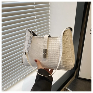 Detail of white crocodile pattern shoulder bag with silver chain strap and metal swivel lock