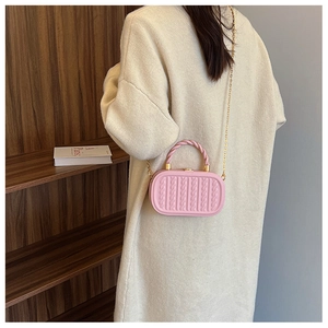 Pink crossbody box bag with vertical embossed texture and twisted handle shown on model