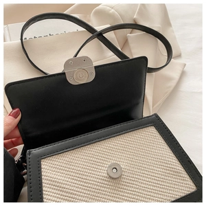 Détail du sac bandoulière tissé noir et beige avec fermoir magnétique et lanière en cuir