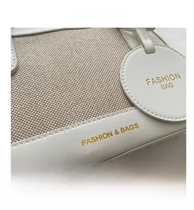 Close-up of leather and canvas stitching with woven texture and gold foil lettering