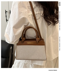 Detail of stitched canvas and brown leather panels with gold Fashion Bag lettering