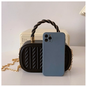 Mini black hardshell handbag with embossed vertical texture and gold chain strap comparison