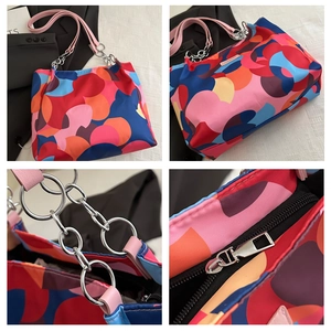 Detail view of colorful geometric print tote bag with metal chain handles and zipper