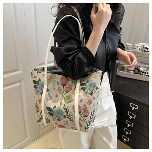 Close-up of floral jacquard fabric and white leather straps on a stylish tote bag