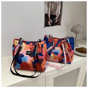 Detailed macro view of trendy contrast color tote bag with metal chain strap on desk
