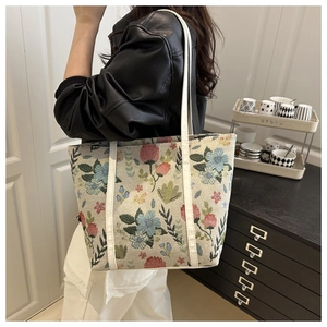 Detail of floral jacquard tote bag with white leather straps and vintage flower pattern