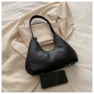 Detail of minimalist black PU leather hobo bag with white logo and thin shoulder strap