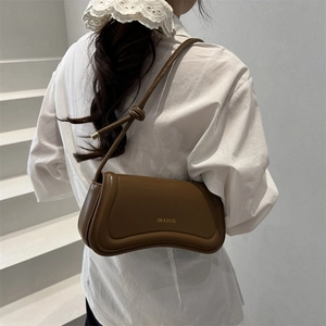 Minimalist brown curved leather shoulder bag with gold embossed logo and knotted strap