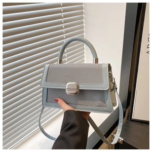 Détail du sac à bandoulière bleu clair avec texture tissée et boucle argentée métallique