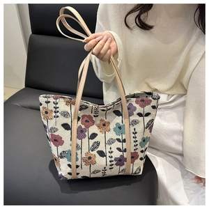 Detail of vintage floral pattern jacquard fabric tote bag held by model