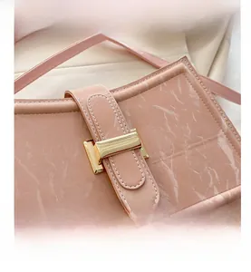 Macro shot of pink marble pattern faux leather with a rectangular gold metal clasp detail