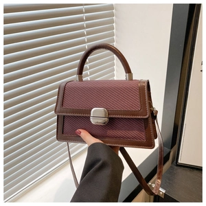 Détail d'un petit sac carré contrasté avec tissage texturé et boucle en métal
