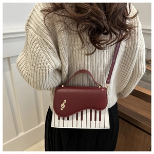 Detail view of the piano keyboard pattern and treble clef ornament on the chic bag