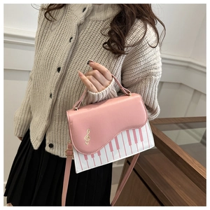 Detail of pink piano key print and treble clef hardware on stylish crossbody bag