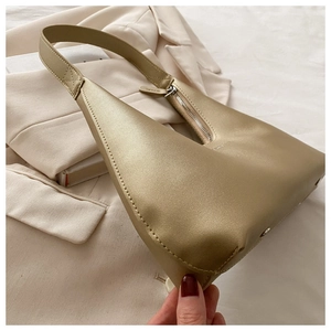 Detail of champagne gold matte leather hobo bag with sleek zipper and shoulder strap