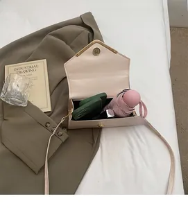 Detailed interior of minimalist off-white envelope crossbody bag showing ample storage space
