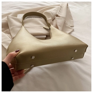 Detailed view of the golden metallic handbag base with silver protective metal studs