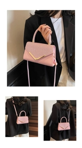 Detail of pink flap bag with glitter finish, gold V hardware and adjustable strap