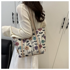 Detail of floral tote bag with vintage flower patterns and brown leather straps