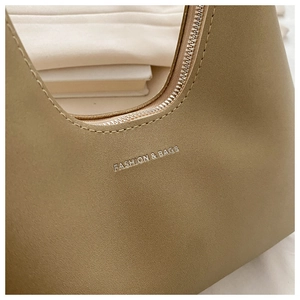 Detail of khaki textured shoulder bag featuring silver Fashion & Bags logo print