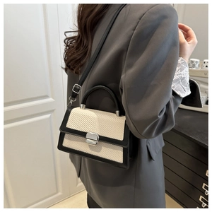 Détail de la texture tissée et du cuir noir avec boucle carrée argentée sur le sac