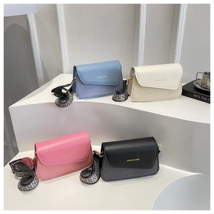 Detail of colorful crossbody bags with wide checkered straps and woven texture