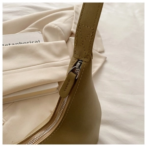 Detail of silver metal zipper and reinforced X-stitching on the khaki hobo shoulder bag