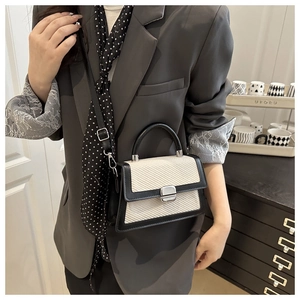 Détail du sac bandoulière avec texture tissée et bordures en cuir noir élégantes
