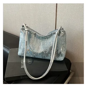 Detail of light blue denim shoulder bag with silver sequins and metallic woven handle