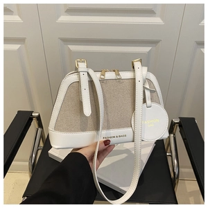 Detail of canvas and leather tote with gold metal hardware and fashion text tag