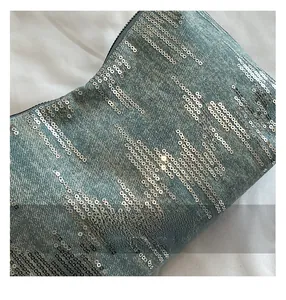 Detailed view of light blue denim shoulder bag with radiating silver sequins embroidery