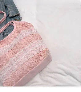 Détail du sac cabas en dentelle rose avec broderie florale et tissu en maille étagée