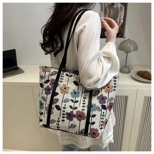 Close-up of floral jacquard tote bag with elegant embroidery and slim leather straps