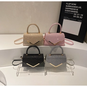 Detail of glitter envelope bags in gold, pink, black and grey with V-shaped metal trim