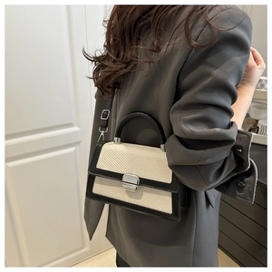 Mannequin portant un sac à bandoulière tissé beige avec garniture noire et boucle argent