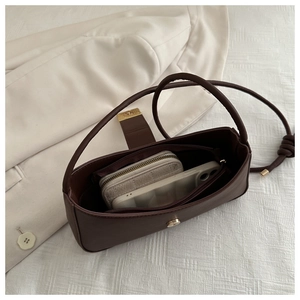 Detail view of the spacious interior of a dark brown faux leather crescent underarm bag