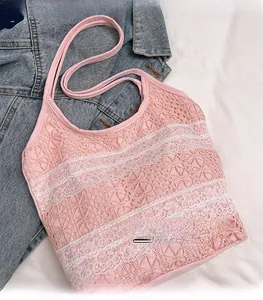 Gros plan d'un débardeur en dentelle rose avec broderie florale et bordure blanche