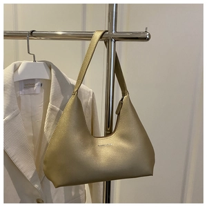 Detail showing metallic champagne gold hobo bag texture and elegant zipper closure