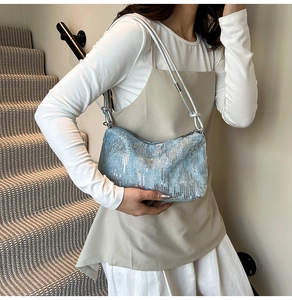 Close-up of stylish light blue sequin shoulder bag with silver metallic rope strap details