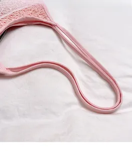 Détail du sac cabas en dentelle rose montrant la poignée en toile et la bordure en dentelle