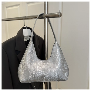 Detail of silver crescent bag featuring snake skin texture and metal protective feet