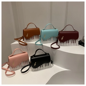 Detailed display of five colorful handbags featuring piano key patterns and gold treble clef