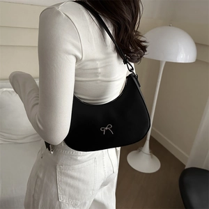Detail of black crescent hobo bag with silver metallic bow buckle and adjustable strap