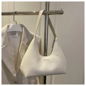 Detail of minimalist white crescent underarm bag with black fashion text on matte leather